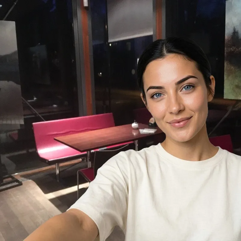 I am in a light T-shirt at Pavilon Grébovka, with a pink bench, a wooden table and dark glass walls behind me.